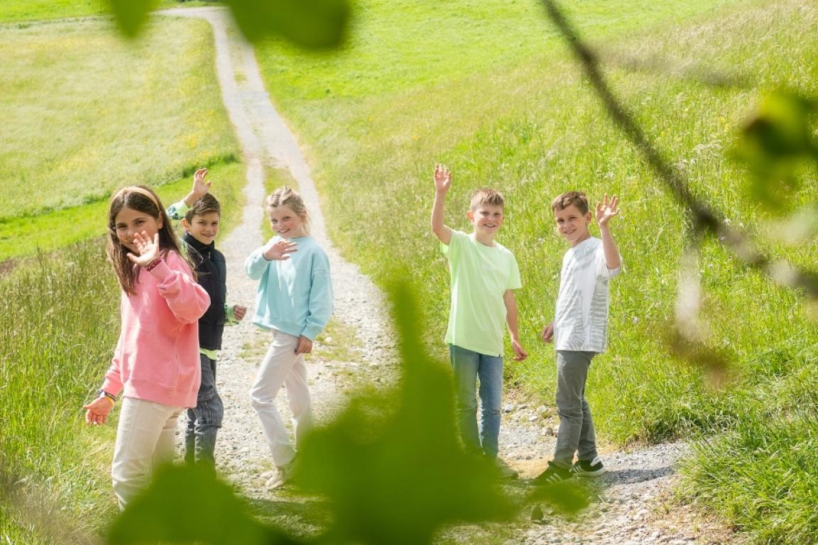 Fröhliche Kinder winken vor Chocolarium im Botsberger Riet